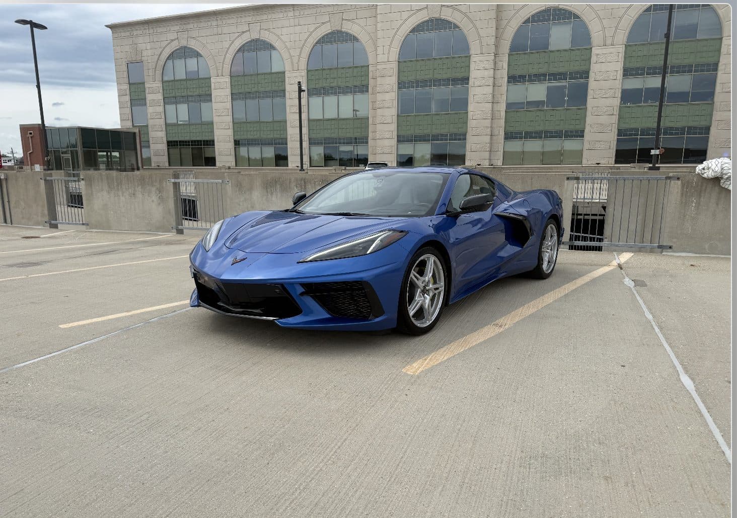 Glossy blue C8 Corvette detailed and gleaming on a parking deck