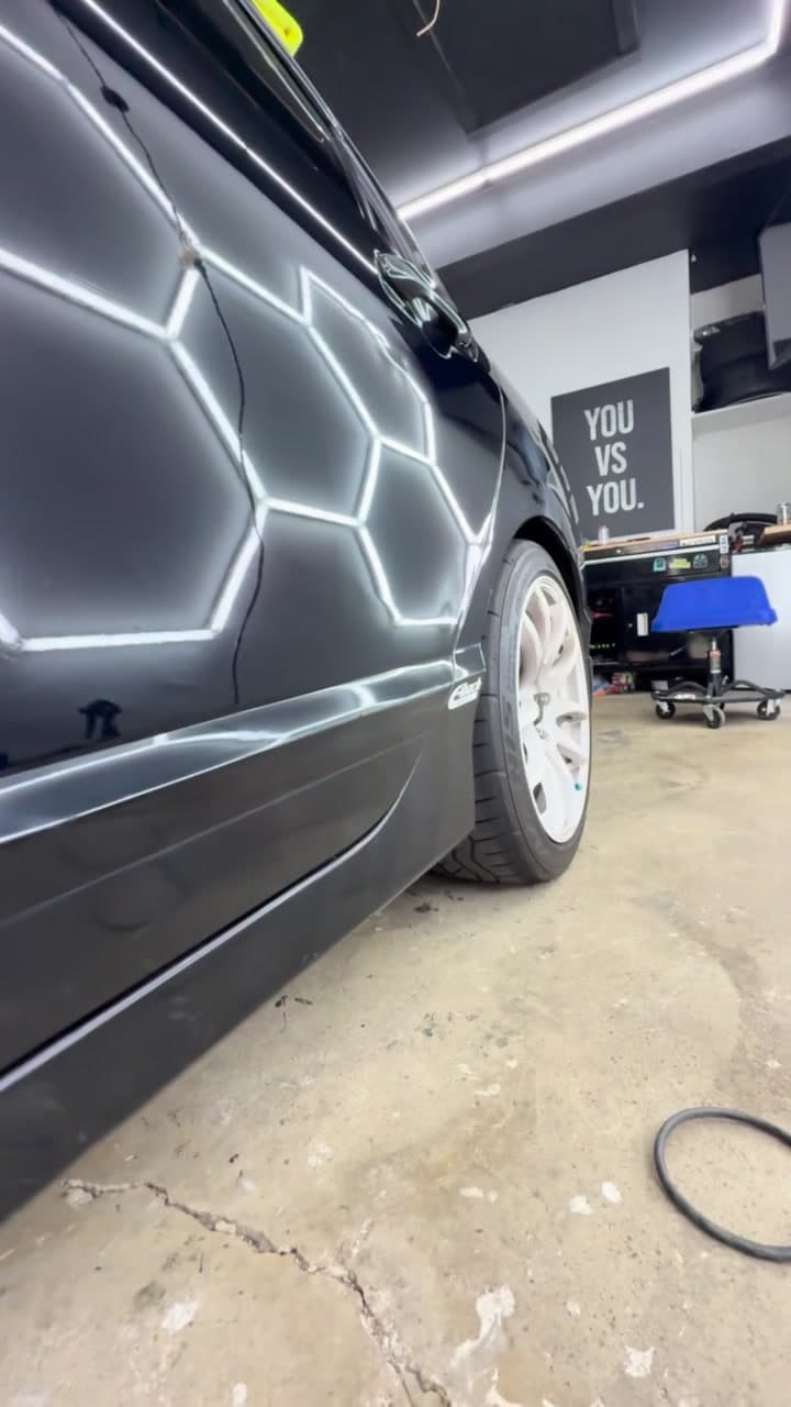 Glossy black paint reflecting a crisp honeycomb LED pattern after correction