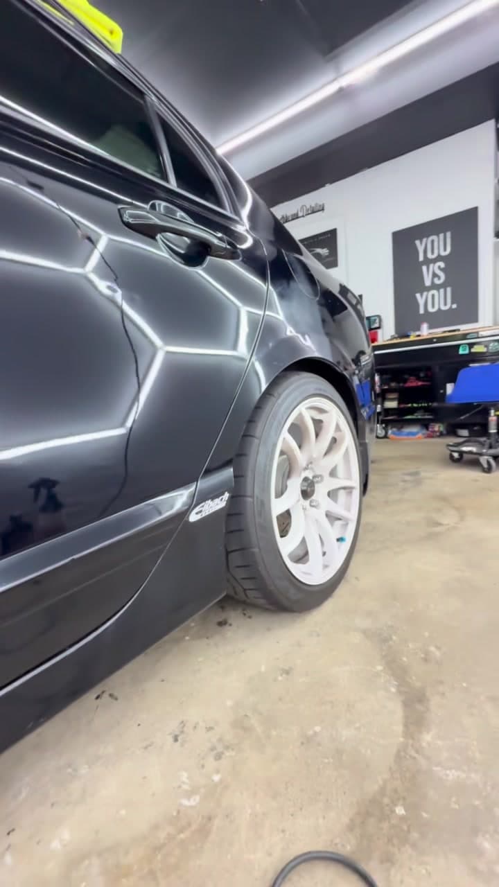 Mirror-finish reflection on a freshly detailed black vehicle